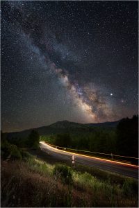 Car light streaks on US 101 beneath the starry skies