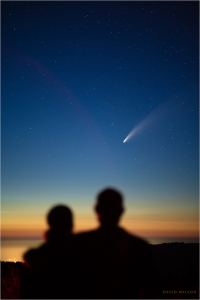 A couple silhouetted against the sky, watching Comet NEOWISE