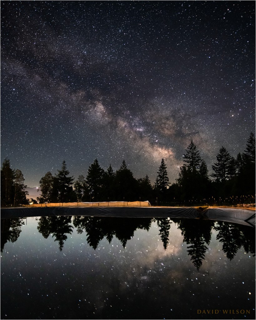 A catchment pond reflects the night sky