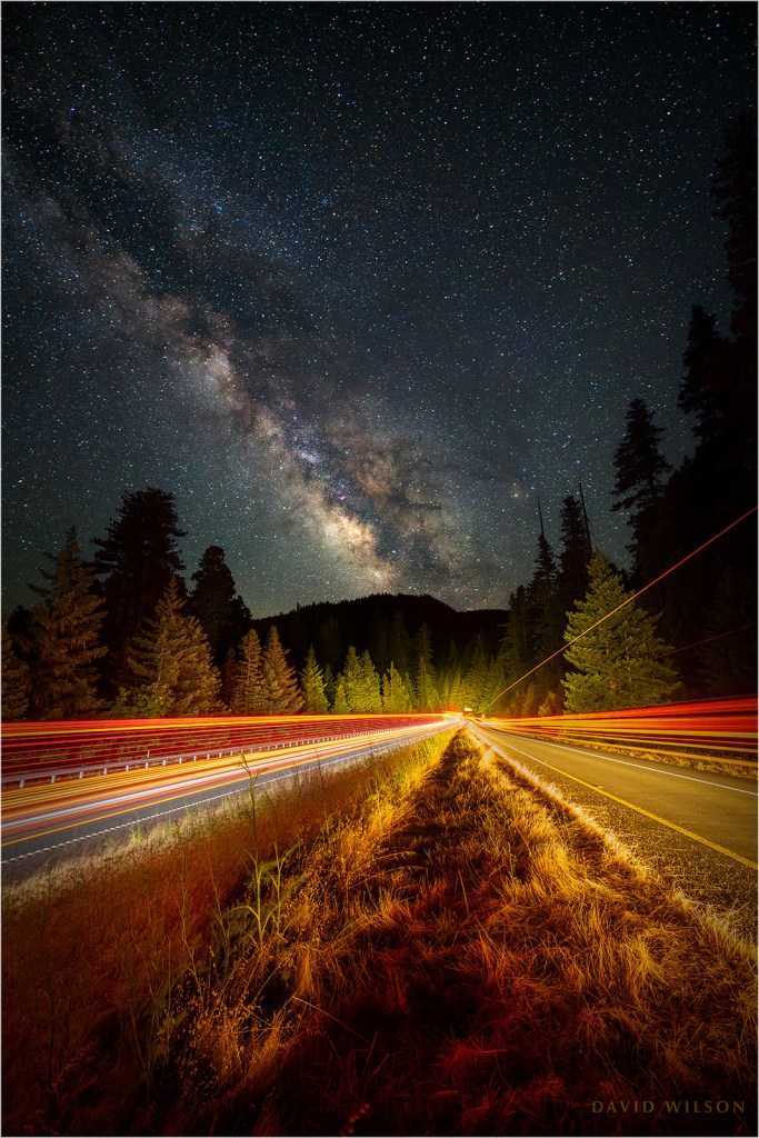 Nighttime view down US 101 with taillight streaks and the Milky Way.